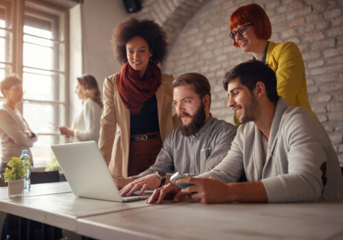 Image of web designers gathered around a computer