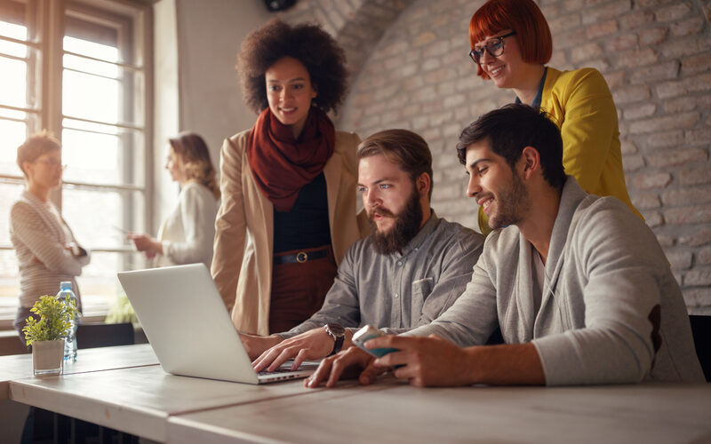 Image of web designers gathered around a computer